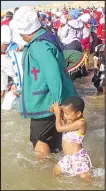  ?? ?? A child enjoying as she enters the sea with her relative.