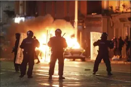  ?? BRIAN LAWLESS — PA VIA AP ?? A car burns as policemen stand at the scene of an attack in Dublin on Thursday.