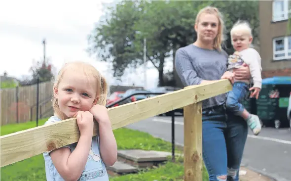  ??  ?? Beth Harrison with daughter Daisy Webster, two, and Millie Webster, four, with the half completed fence.
