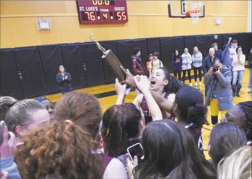  ?? Matthew Brown / Hearst Connecticu­t Media ?? St. Luke’s Caroline Lau celebrates with the trophy following the Storm’s 76-55 win against Green Farms Academy in the FAA girls basketball final in New Canaan, on Friday.