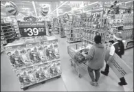 ?? AP/JULIO CORTEZ ?? A customer and a Wal-Mart employee walk through the toy section at a store in Teterboro, N.J., in October. The Institute for Supply Management’s measure of the service economy showed expansion in November.