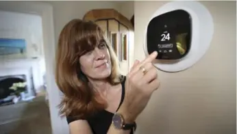  ?? RICHARD LAUTENS/TORONTO STAR ?? Diana Carradine uses an Ecobee smart thermostat, which allows users to control temperatur­e when not at home.