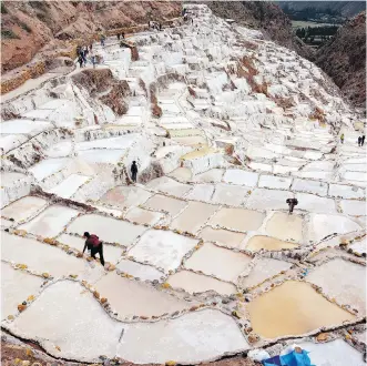  ??  ?? Visitors clamber among the ancient salt pans of Maras. Quality salt is still mined here.