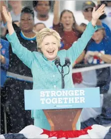  ?? Wilfredo Lee Associated Press ?? HILLARY CLINTON embraces a sudden downpour at a rally in Pembroke Pines, Fla., a crucial Democratic stronghold.