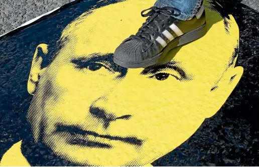  ?? AP ?? A man steps on a portrait of Russian President Vladimir Putin during an opposition rally in Moscow.