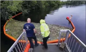  ?? CHARLES KRUPA — THE ASSOCIATED PRESS ?? In this Wednesday, June 7, 2017 photo, activist Rocky Morrison, left, and volunteer Dalton Abbott, of the “Clean River Project” examine a boom filled with waste collected from a recovery boat on the Merrimack River in Chelmsford, Mass. Syringes left by...