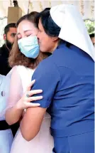  ??  ?? A KISS OF THE ALL CLEAR: A nurse who had lovingly tended her gives a warm embrace to show she’s completely virus free