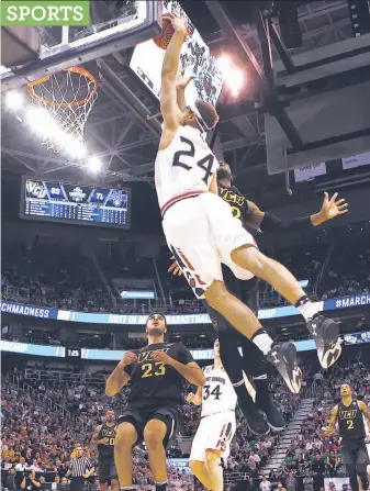  ?? Christian Petersen / Getty Images ?? St. Mary’s sharpshoot­er Calvin Hermanson soars in for a dunk over VCU’s Mo Alie-Cox.