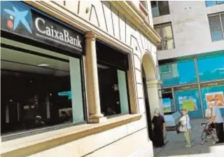  ?? EFE/TONI ALBIR ?? Oficina de CaixaBank, que se ha fusionado con Bankia