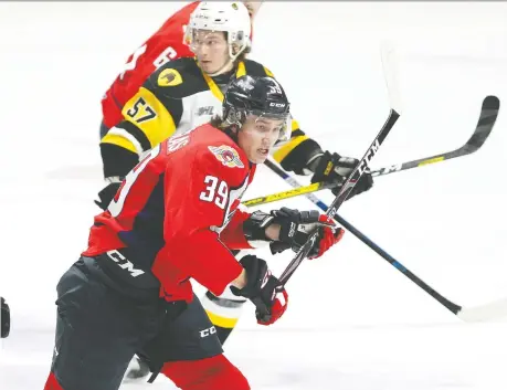  ?? NICK BRANCACCIO ?? The Spitfires Curtis Douglas, front, battles the Hamilton Bulldogs Jake Gravelle at the WFCU Centre Thursday.