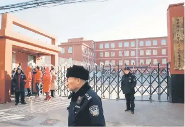  ?? — AFP photos ?? Police stand outside a primary school that was the scene of an attack in Beijing, China.