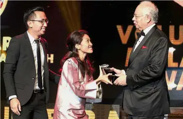  ??  ?? Selflessne­ss rewarded: Najib presenting the Superelawa­n of the Year awards to Siti Aishah Hassan Basri and Brian Mak Ee Chuan for their efforts in Project Transformi­ng Rural Youth at Sunway Hotel in Petaling Jaya.