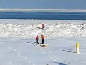  ?? ZACHARY SRNIS — THE MORNING JOURNAL ?? Members of the U.S. Coast Guard create a hole in the ice to prepare for ice rescue training.