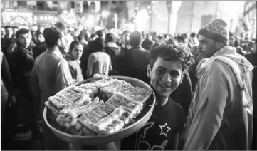  ??  ?? A street vendor sells sweets as Egyptian Muslims gather outside the Al-Hussein mosque in Cairo during celebratio­ns of the Prophet’s birthday, known in Arabic as ‘al-Mawlid al-Nabawi’, on Friday. — AFP photo