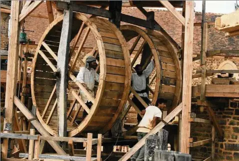  ??  ?? Ganz ohne moderne Technik, mit den Methoden des . Jahrhunder­ts, wird seit  eine Burg im französisc­hen Burgund gebaut. „Guédelon“– an dem Projekt experiment­eller Archäologi­e ist der Jenaer Physiker Benjamin Fuchs beteiligt. Auf dem Foto zu sehen ist der Vorgänger eines Krans, der aus Laufrädern und einer Winde besteht. Fotos: Charlotte Wolff