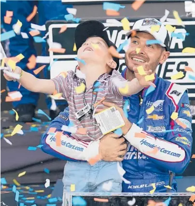  ?? RICK SCUTERI/AP ?? Kyle Larson holds his son, Owen, after winning his first NASCAR Cup Series championsh­ip Sunday at Phoenix Raceway.