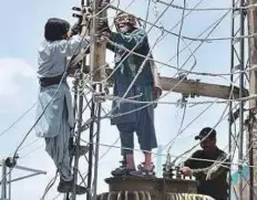  ?? APP ?? Utility workers carry out repairs next to a power transforme­r. Load-shedding during Ramadan has once again become a burning issue for residents of Peshawar and Chitral.