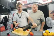  ?? JASON PAYNE/ PNG ?? Paul ( left) and Gord Rundle show how to slice a tomato with a razor- sharp knife they sharpened with their Kleva Sharp knife sharpener, which they sell at the PNE Marketplac­e.
