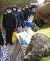  ?? UKRAINIAN PRESIDENTI­AL PRESS OFFICE VIA AP ?? Russia-backed separatist prisoners of war, wearing masks to protect against the coronaviru­s, line up during a prisoner exchange near Gorlivka in eastern Ukraine on Thursday.