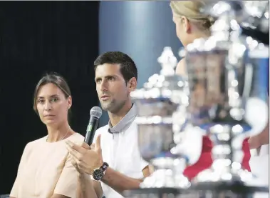  ?? AP ?? Reigning US Open women’s champion Flavia Pennetta looks on as men's title winner Novak Djokovic talks to the media.