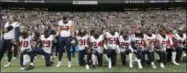  ?? ELAINE THOMPSON — THE ASSOCIATED PRESS FILE ?? In this file photo, Houston Texans players kneel and stand during the singing of the national anthem before an NFL football game against the Seattle Seahawks, in Seattle. The NFL Players Associatio­n filed a grievance with the league challengin­g its national anthem policy.