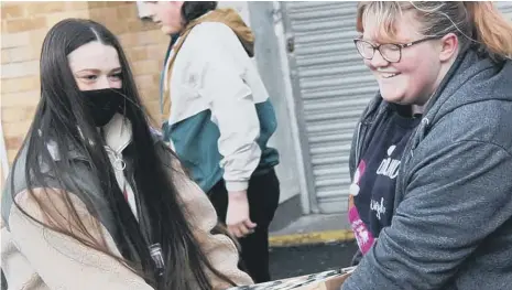  ?? ?? Students Madison Slee, 16, and Kirsty Young, 17, delivering some of the 3,000 tins.