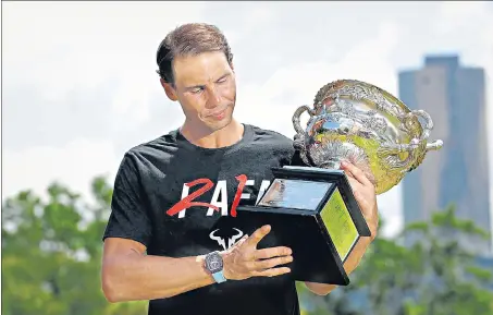  ?? ?? Spain's Rafael Nadal poses with the Australian Open trophy the morning after his victory in the men's singles final at Melbourne Park .