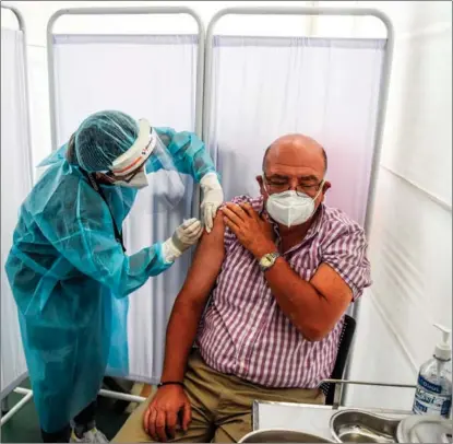  ?? ERNESTO BENAVIDES / AFP ?? A health worker inoculates a volunteer with a COVID-19 vaccine produced by Chinese healthcare group Sinopharm during its trial at the Clinical Studies Center of the Cayetano Heredia University in Lima, Peru, on Dec 9.