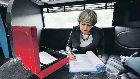  ?? WPA POOL / GETTY ?? La primera ministra británica, Theresa May, trabajando en su autobús de campaña