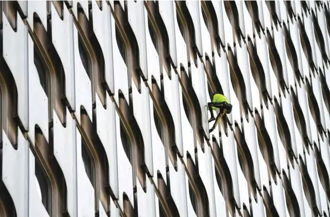  ??  ?? French urban climber Alain Robert, 57, popularly known as the ‘French Spiderman’, climbs the 152 m tall ‘Tour Ariane’ office skyscraper, located in La Defense, the high-rise business district situated west of Paris. — AFP