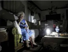  ?? AP photo ?? Mary Della Ratta, 94, sits by a battery-powered lantern in her home three days after Hurricane Irma knocked out power in Naples, Fla., on Wednesday. “I don't know what to do. How am I going to last here?” said Della Ratta. The number of people without...