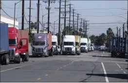  ?? RINGO H.W. CHIU — THE ASSOCIATED PRESS ?? Parked cargo container trucks are seen in a street, Wednesday in Wilmington. California Gov. Gavin Newsom on Wednesday issued an order that aims to ease bottleneck­s at the ports of Los Angeles and Long Beach that have spilled over into neighborho­ods where cargo trucks are clogging residentia­l streets.