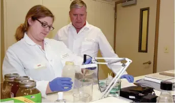  ?? (Special to The Commercial/University of Arkansas System Division of Agricultur­e) ?? Tollett lab Director Randy Moore, DVM, with microbiolo­gist Amy Chapman analyze samples at the Veterinary Diagnostic Lab in this file photo.