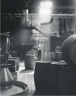  ??  ?? A cooper at work making gin barrels in Coates Gin Distillery, circa 1954