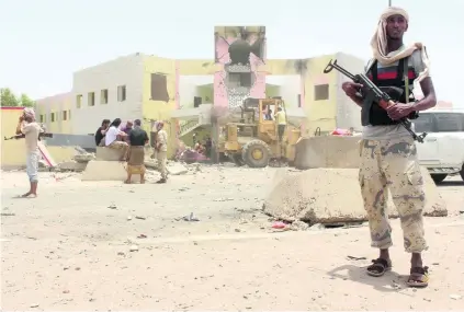  ?? Saleh Al Obeidi / AFP ?? Yemeni security forces guard the site of a suicide car bombing in Aden yesterday claimed by ISIL.