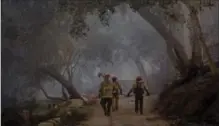  ?? HILARY SWIFT, NYT ?? Firefighte­rs from Riverside County check a property with smoulderin­g ash just over Ventura County border from Carpinteri­a, Calif., Monday.