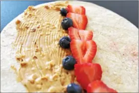  ?? MICHILEA PATTERSON — DIGITAL FIRST MEDIA ?? An alternativ­e to a BP&J sandwich on white bread is replacing the bread with a healthy whole grain wrap then also filling it with fruit like berries. Whole grain items have lots of fiber. Sunflower seed butter can be used instead of peanut butter if...