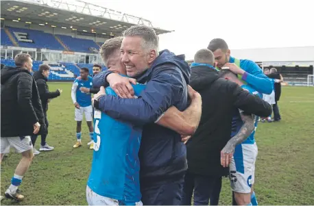  ?? ?? Posh boss Darren Ferguson celebrates promotion from League One with Dan Butler in May, 2021.