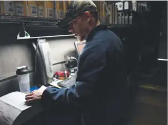  ??  ?? Lake Arbor Automotive & Truck diesel emissions inspector Travis Holmes checks the manual Thursday to find out which inspection­s and devices are needed. Joe Amon, The Denver Post