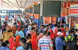  ?? — PTI ?? People flout Covid-19 norms as they stand at a ticket counter to board buses for their native place after authoritie­s announced lockdown in Jaipur on Sunday.