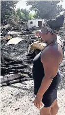  ??  ?? Claudia Grant points at the rubble that was left after the fire in Bell Rock.