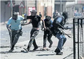  ?? Picture: Alaister Russell ?? Police attempt to arrest a protestor while being pelted with rocks during unrest in Westbury, Johannesbu­rg, this week.