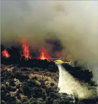  ?? ÀLEX GARCIA / ARCHIVO ?? Un helicópter­o lucha contra las llamas cerca de Darnius, en el 2012