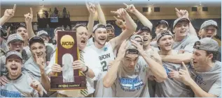  ??  ?? FIRST TITLE: Babson coach Stephen Brennan (with trophy) and players celebrate after winning the NCAA Division 3 college basketball championsh­ip.