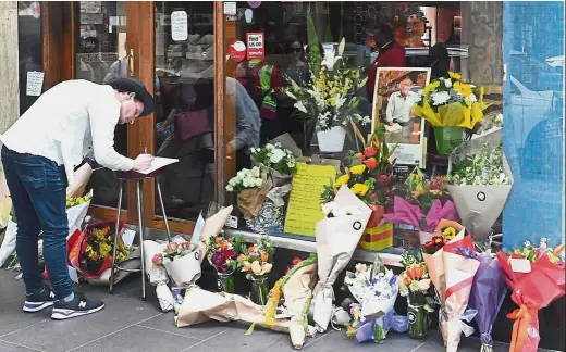  ?? — Reuters ?? In loving memory: Floral tributes placed outside Pellegrini’s Cafe for Malaspina, the day after he was stabbed to death in central Melbourne.