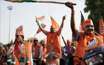  ??  ?? Tilhaenger­e af BJP og Narendra Modi under valgkampen på deres scootere i Ahmedabads gader i Modis hjemstat Gujarat. Indiens premiermin­ister, der kom fra posten som leder af delstats-parlamente­t i Gujarat, vandt en ny stor sejr og får fem år mere på posten. Foto: AP