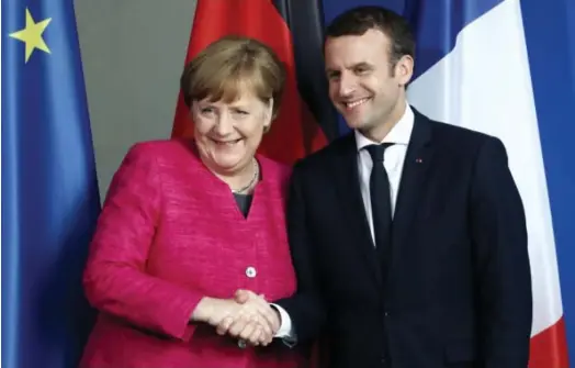  ??  ?? From left: German Chancellor Angela Merkel shaking hands with French President Emmanuel Macron