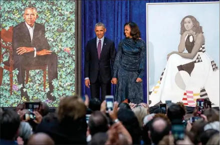  ?? The Associated Press ?? Former President Barack Obama and former first lady Michelle Obama stand as their official portraits are unveiled at the Smithsonia­n’s National Portrait Gallery, Monday, in Washington. Barack Obama’s portrait was painted by artist Kehinde Wiley, and...