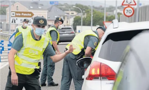  ?? AFP ?? Spanish Civil Guards control a checkpoint on the highway between the regions of Galicia and Asturias in Ribadeo in Spain earlier this month.