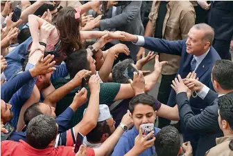  ?? — AFP ?? Turkey’s President Recep Tayyip Erdogan, leader of the Justice and Developmen­t Party and his wife Emine are greeted by supporters as they leave the polling station after casting their votes in Istanbul on Sunday. Turkey’s six Presidenti­al candidates...